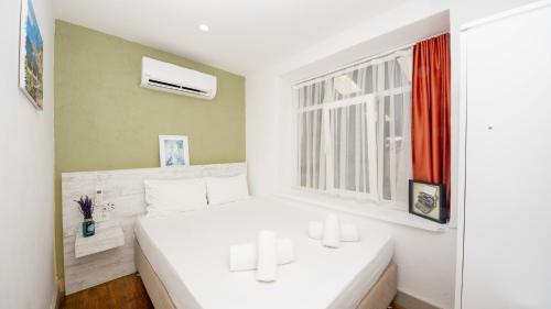 a white bedroom with a bed and a window at LİME BOZCAADA in Bozcaada