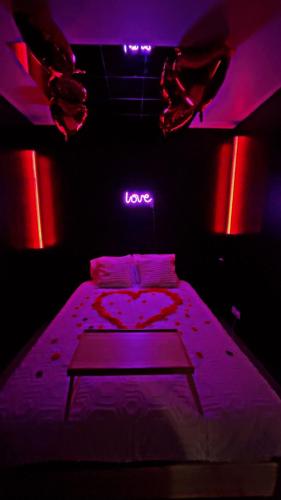 - une chambre avec un lit muni d'un signe d'amour dans l'établissement Meluninlove, à Melun