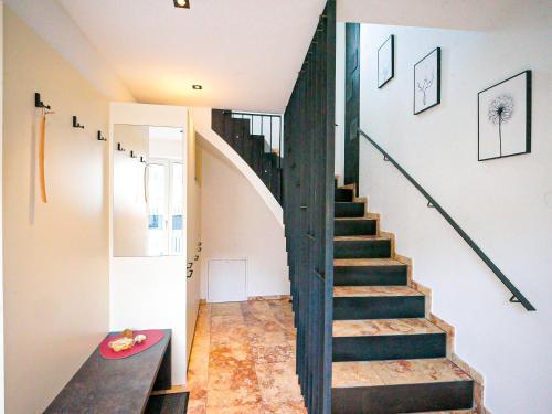 a staircase in a house with a black railing at ROFANLODGE Gutschlhofer - House with Panoramic View in Tyrol, presented by AlpenLuxus in Mariatal