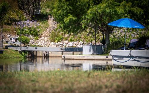 a boat with a blue umbrella on a body of water at Mariri Heights Tasman in Upper Moutere