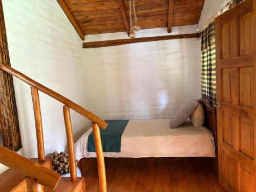 a small bed in a room with a staircase at Hostería el Socavón in Guaranda