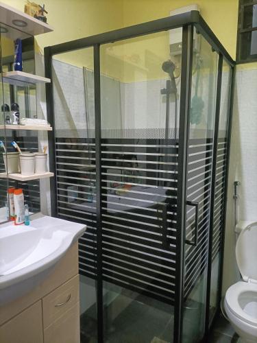 a bathroom with a glass shower with a toilet at Regina's Vacation House in Tayud