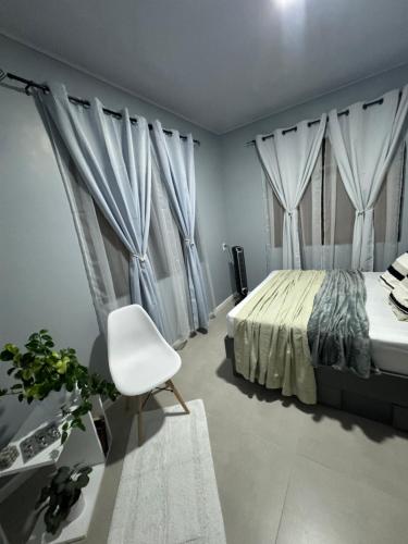 a bedroom with a bed and a white chair at B&B Pacuare River Gateway Tica House in Linda Vista