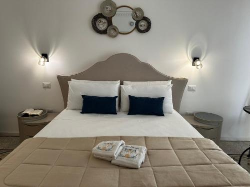 a bedroom with a large bed with two towels on it at Terra d'amuri Rooms in Terrasini