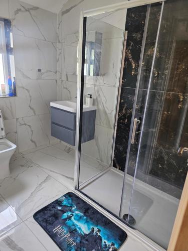 a bathroom with a shower and a book on the floor at Potters Hideout- 2 Bedroom 2 Bathroom Apartment in Watford