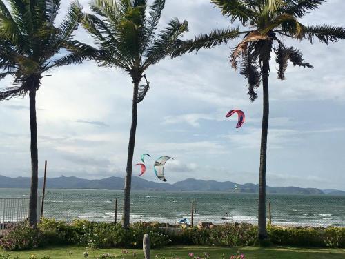a group of kites flying over the ocean with palm trees at Casa Punta Chame in Punta Chame