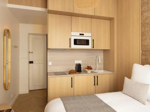 une petite cuisine avec un four micro-ondes au-dessus d'un comptoir dans l'établissement Charming Cosy Studio - 2P - Gare Saint Lazare, à Paris