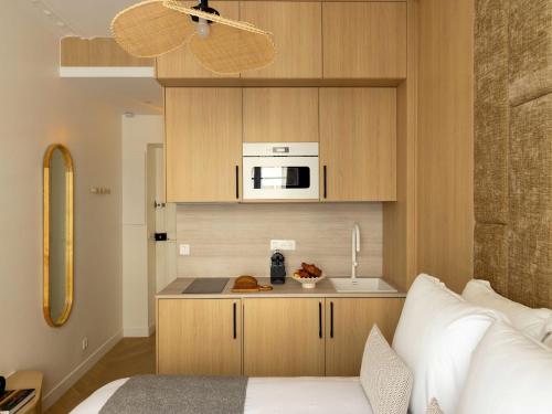 - une cuisine équipée d'un four micro-ondes et un lit dans une chambre dans l'établissement Charming Cosy Studio - 2P - Gare Saint Lazare, à Paris