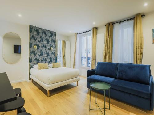- un salon avec un canapé bleu et un lit dans l'établissement Modern studio - 4P- Sacré-Coeur, à Paris