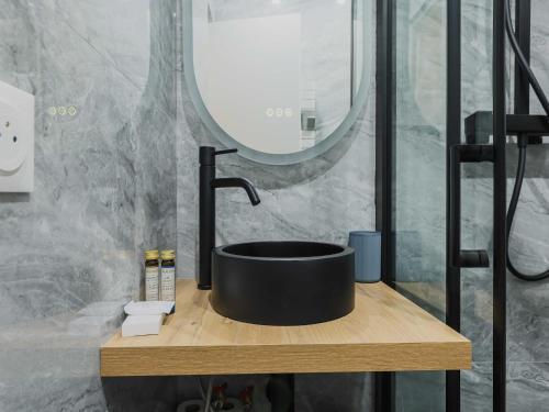 une salle de bain avec un lavabo noir et un miroir dans l'établissement Modern studio - 4P- Sacré-Coeur, à Paris