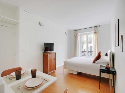 a white bedroom with a bed and a table at Modern and Cosy Studio - 2P - Rueil-Malmaison in Rueil-Malmaison