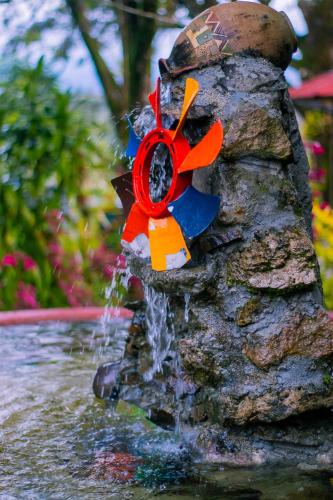 a water fountain with a flower on a rock at hostal Sueño Paraiso- Observatorio astronómico in Popayan