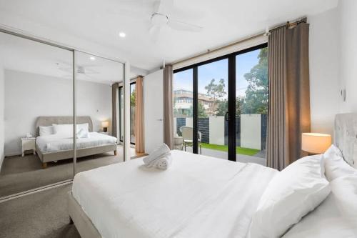 a bedroom with two white beds and a large window at XV - Sun Soaked Ultimate Bentleigh Convenience in Melbourne