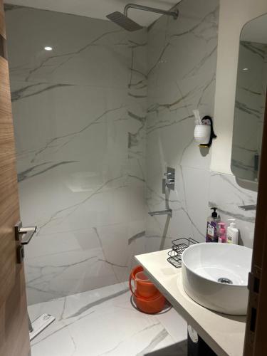 a white bathroom with a sink and a shower at Atithi Dream Studios in Gurgaon
