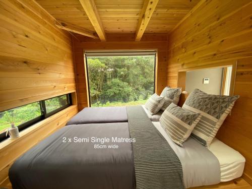 un letto in una camera con una grande finestra di Le Lodge Mimitsu a Hyuga