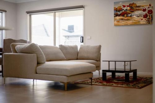 a living room with a couch and a table at Hartleigh Estate - Sophisticated Family Living in Clyde