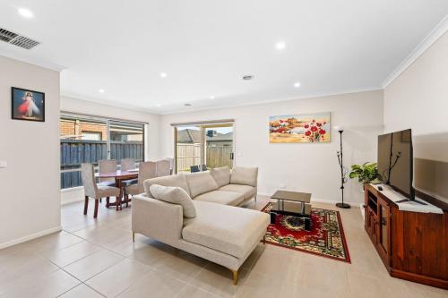 a living room with a couch and a tv and a table at Hartleigh Estate - Sophisticated Family Living in Clyde