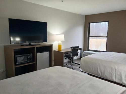 a hotel room with a bed and a desk with a television at Comfort Inn near Downtown & Blue Ridge PKWY in Marion