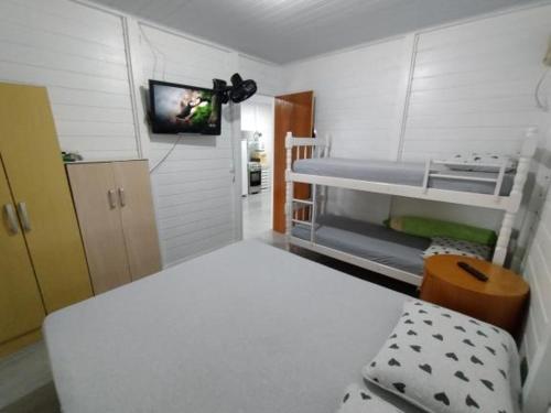 Habitación pequeña con litera y TV. en Cantinho do Sossego, en Porto Belo