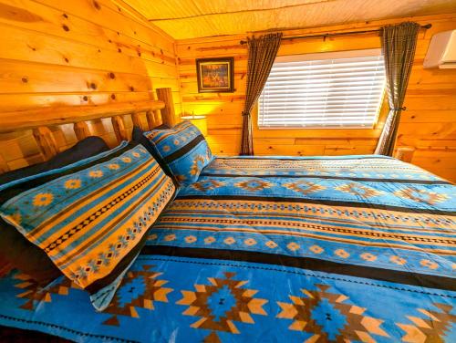 a bedroom with a bed in a log cabin at Yellowstone Treasure Guesthouses on the River in Gardiner