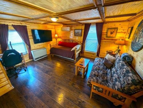 a living room with a couch and a tv at Yellowstone Treasure Guesthouses on the River in Gardiner