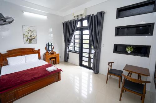 ein Schlafzimmer mit Bett, Schreibtisch und Fenster in der Unterkunft Motel Thái Bình 2 in Thôn Trường Giang