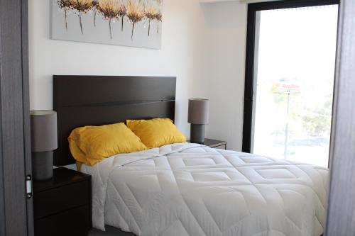 a bedroom with a white bed with a black headboard at Loft Cerca Plaza Mayor in Miravalle