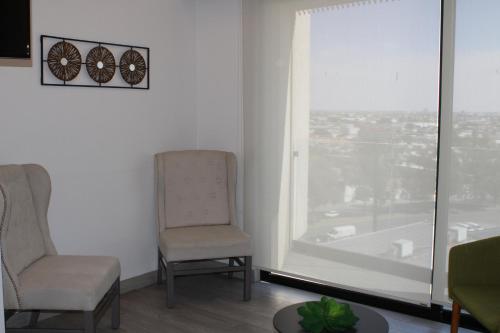 two chairs and a table in a room with a window at Loft Cerca Plaza Mayor in Miravalle
