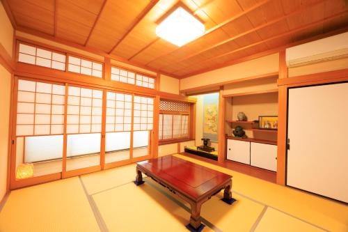 a room with a table in a room with windows at 悠吉野別邸VillaYuYOSHINO in Yoshino