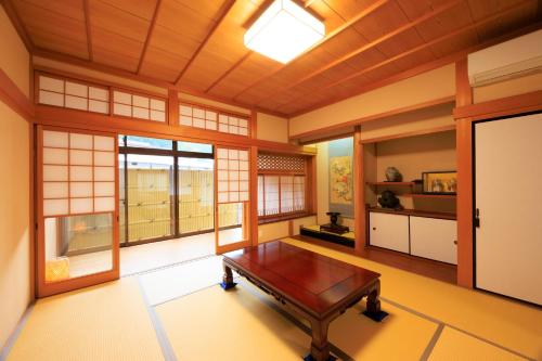 a room with a table in a room with windows at 悠吉野別邸VillaYuYOSHINO in Yoshino