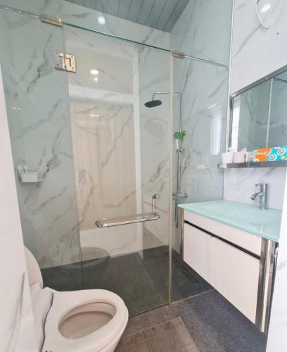 a bathroom with a shower and a toilet and a sink at De Lavender Villa 1 in Citaringgul 1