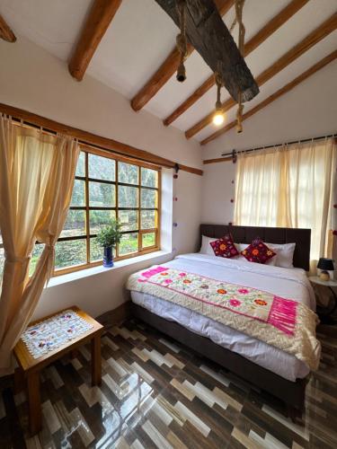 Un dormitorio con una cama grande en una habitación con ventanas. en Sacred Garden Home, en Cusco