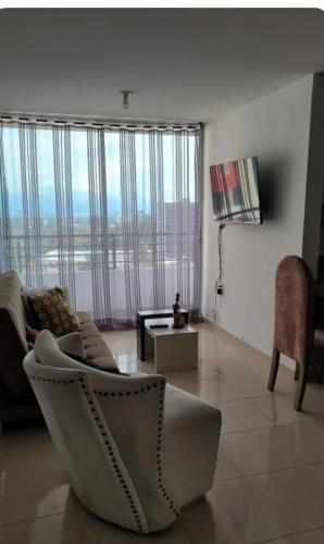 a living room with a couch and a chair at David Cómodo Apartamento con Piscina in Armenia