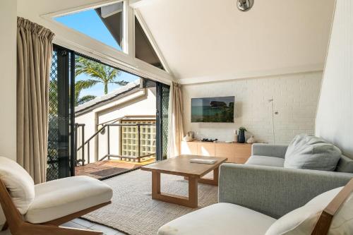 a living room with a couch and a table at Byron Bay Beachfront Holiday Apartments in Byron Bay