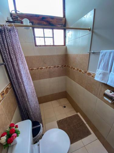 a bathroom with a shower with a toilet and a sink at Casa Pájaro Azul - Isinliví in Hacienda La Provincia