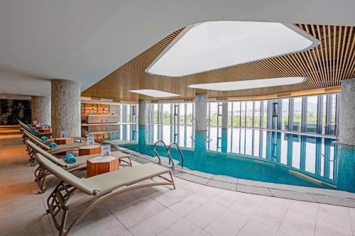 a pool in a building with chairs and a swimming pool at Spring ALacarte Ha Long Luxury Studio in Ha Long