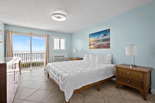 a bedroom with a bed and a balcony at Oceanfront Inn Room #23 - Ocean View Balcony King Bed in Fort Pierce