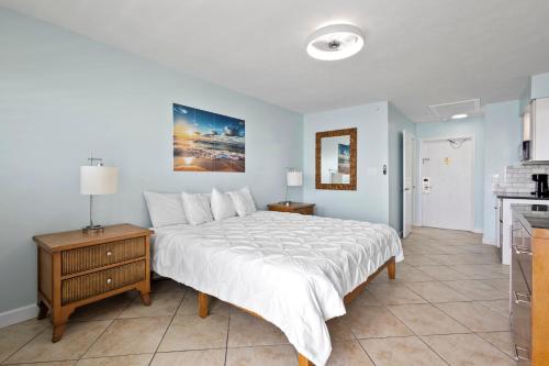 a bedroom with a large bed and a kitchen at Oceanfront Inn Room #23 - Ocean View Balcony King Bed in Fort Pierce