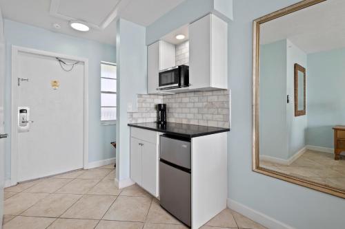 a kitchen with a counter top and a mirror at Oceanfront Inn Room #23 - Ocean View Balcony King Bed in Fort Pierce