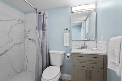 a bathroom with a toilet sink and a shower at Oceanfront Inn Room #23 - Ocean View Balcony King Bed in Fort Pierce