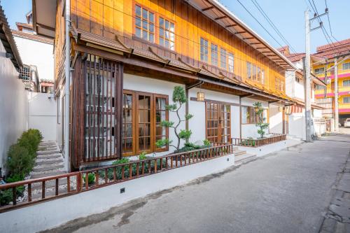 a building with wooden doors and windows on a street at Thongkwao house in Chiang Mai