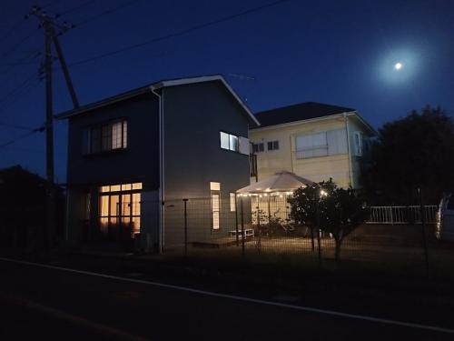 a house at night with the moon behind it at ビーチまで徒歩5分 BBQ無料 7名迄OK 戸建て貸切宿 Bignet villa in Miyamae