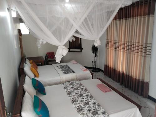 two beds in a room with curtains at Ella Nature valley homestay in Ella