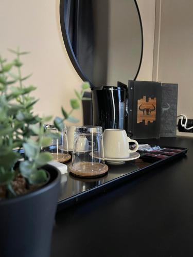 a table with cups and a coffee maker and a plant at The Steakhouse - Guest Rooms in Sankt Johann im Pongau