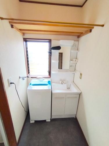 a small bathroom with a sink and a window at ビーチまで徒歩5分 BBQ無料 7名迄OK 戸建て貸切宿 Bignet villa in Miyamae