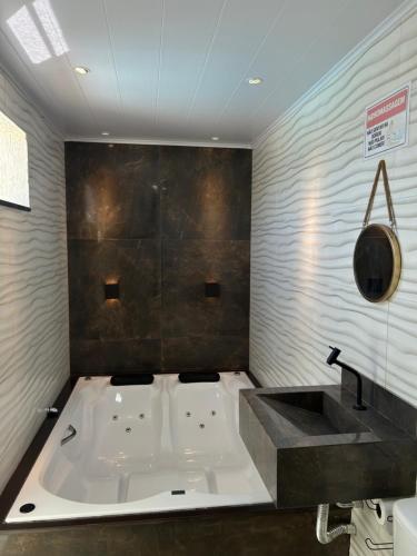 a bathroom with a bath tub and a sink at Casa temporada Cabo Frio Casa pôr do Sol in Cabo Frio