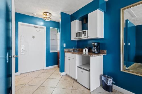 a kitchen with blue walls and a counter at Oceanfront Inn Room #21- Ocean View Balcony King Bed in Fort Pierce