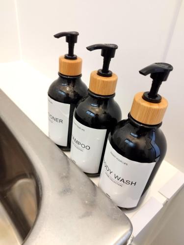 three bottles of soap sitting on a counter next to a sink at ビーチまで徒歩5分 BBQ無料 7名迄OK 戸建て貸切宿 Bignet villa in Miyamae