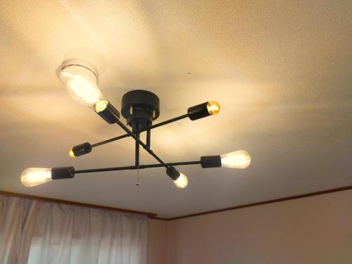 a chandelier hanging from the ceiling in a room at ビーチまで徒歩5分 BBQ無料 7名迄OK 戸建て貸切宿 Bignet villa in Miyamae
