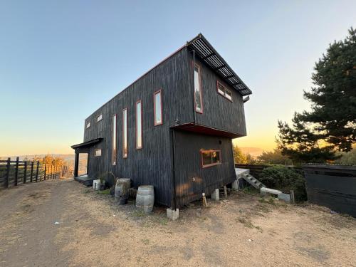 a black house sitting on top of a hill at La madriguera Matanzas in Navidad